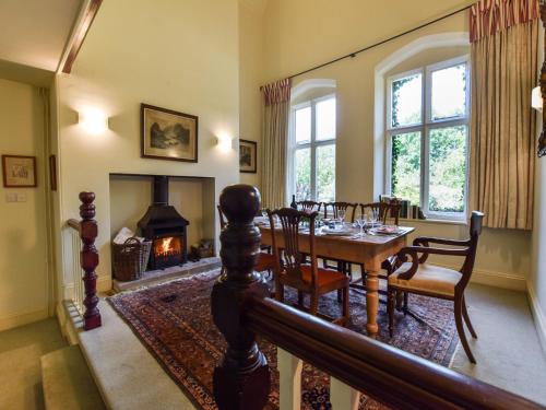 a dining room with a table and a fireplace at Bellhouse in Stonehouse