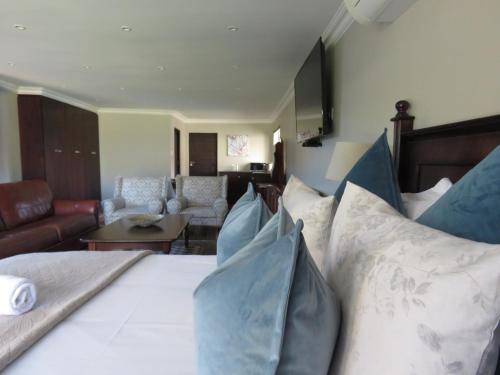 a bedroom with a bed with pillows on it at Abiento Guesthouse in Bloemfontein