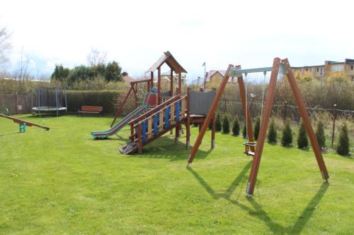 a playground with a slide in a yard at Wrzosowa komnata in Darlowko