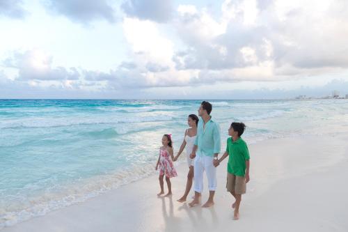 a family standing on the beach at Krystal Cancun in Cancún