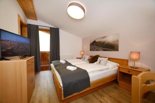 a bedroom with a large bed and a television at Chalet Kirsten in Zell am See