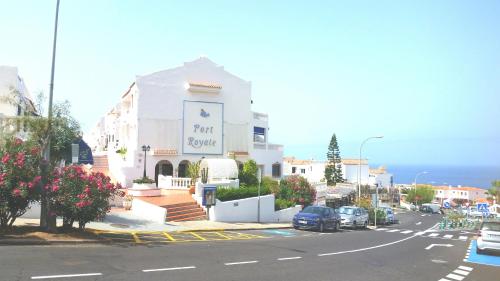 a white building with a sign on the side of a street at Charming studio Los Cristianos Hill heated pool in Los Cristianos