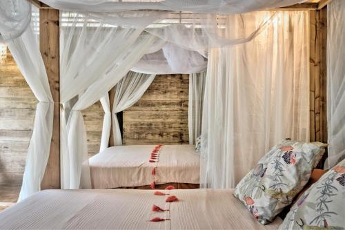 a bedroom with two beds and a canopy at La Shamana - Ecological Concept in Jungle in Cahuita