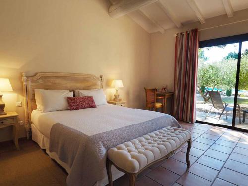 a bedroom with a large bed and a large window at Le Clos des Cyprès Maison d'hôtes de charme & Diner Gourmet in Graveson