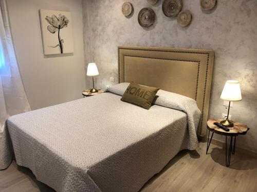 a bedroom with a large bed with two lamps at La Laguna Luxe Apartment in La Laguna