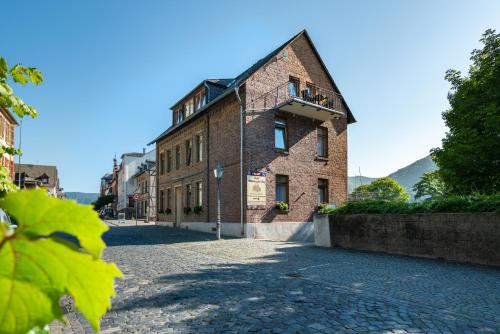 an old brick building on a cobblestone street at Altkölnischer Hof in Bacharach