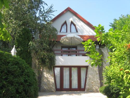 a brick house with a garage with an umbrella at Flair Apartmanház in Eger