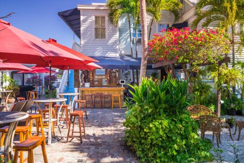 an outdoor patio with tables and chairs and umbrellas at Duval Inn - Key West in Key West
