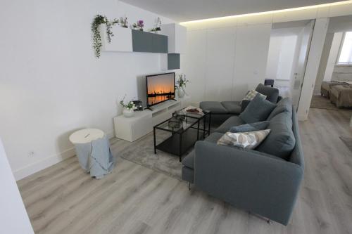 a living room with a couch and a fireplace at Apartamento das Malheiras in Viana do Castelo