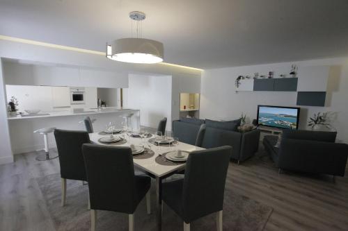 a dining room and living room with a table and chairs at Apartamento das Malheiras in Viana do Castelo