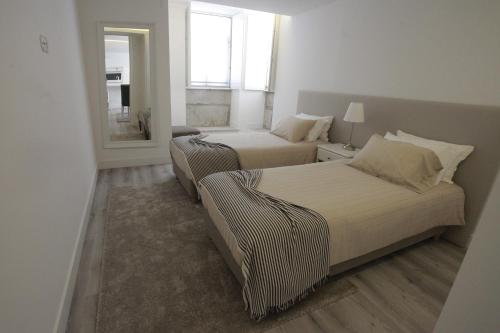 sypialnia z 2 łóżkami i lustrem w obiekcie Apartamento das Malheiras w mieście Viana do Castelo