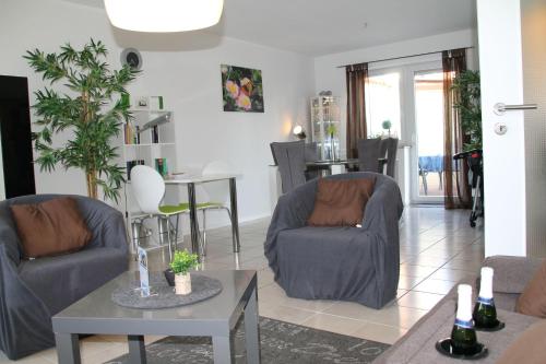 ein Wohnzimmer mit 2 Stühlen und einem Tisch in der Unterkunft Ferienwohnung Ferienliebe Lahn Dill in Hochelheim