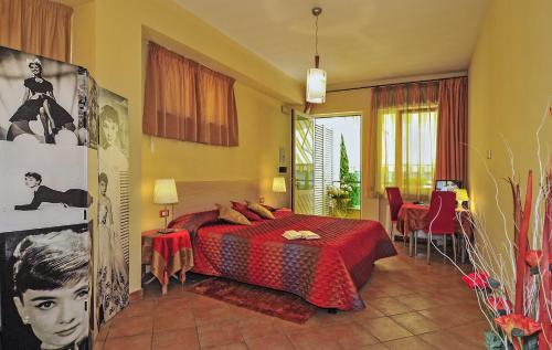 1 dormitorio con 1 cama con colcha roja en B&B Ai Cipressi, en Lucca