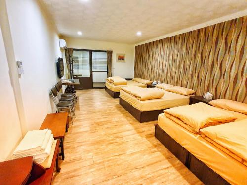 a room with four beds and a television in it at Fun Shili B&B in Shuili