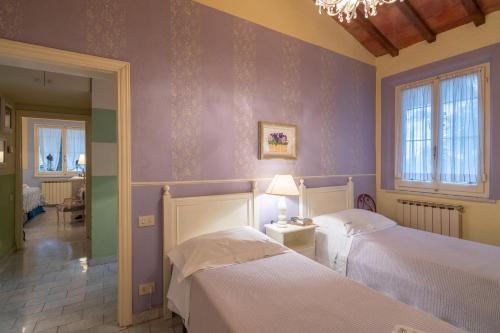 ピエーヴァ・スクオーラにあるVillino Single House Garden Shared Pool Wi-Fiの紫の壁のベッドルーム1室(ベッド2台付)