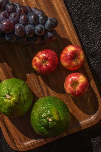 a group of apples and grapes on a wooden plate at Yakamoz Erhai Hotel in Dali