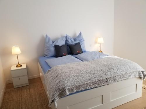 a bedroom with a bed with blue sheets and pillows at Heimathaven 2 in Bremerhaven