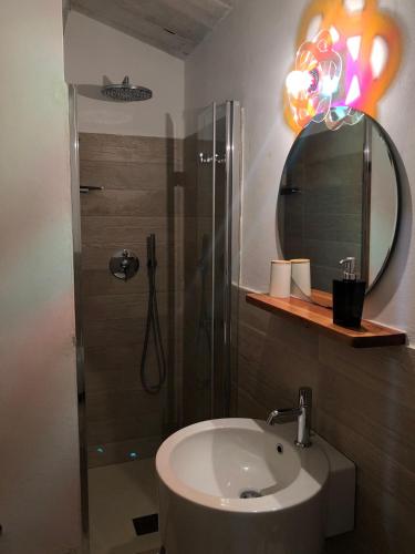a bathroom with a sink and a shower with a mirror at La Locanda Della Campanara in Santa Sofia