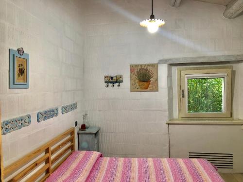 a bedroom with a bed and a window at La Locanda Della Campanara in Santa Sofia