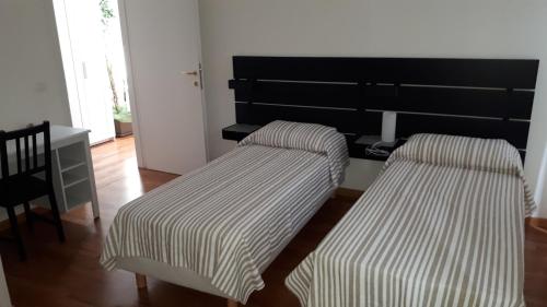 duas camas num quarto com uma mesa e uma cadeira em al 106 em Trieste