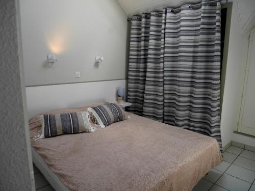 une chambre avec deux lits et une fenêtre dans l'établissement REF 041 Appartement pour quatre personnes vue mer accès plage et parc du Fogeo ARZON, à Arzon