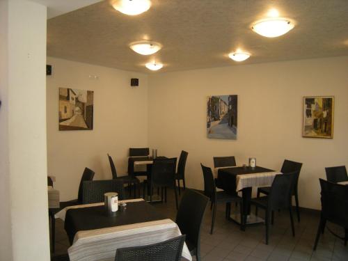 a dining room with tables and chairs and paintings on the walls at al 106 in Trieste