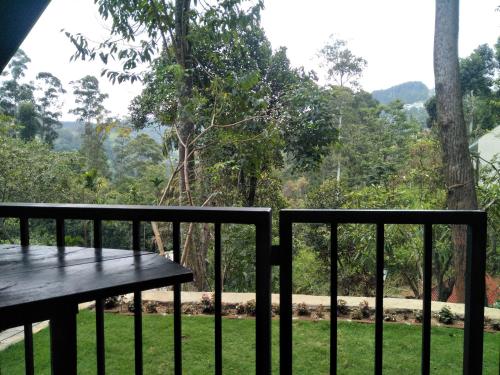 a bench on a balcony with a view of a park at Fair View Cottage in Ella
