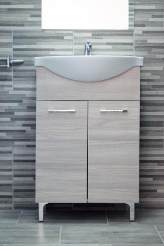 a bathroom with a sink and a mirror at Elixír Apartman in Villány