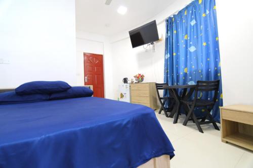 a bedroom with a blue bed and a table and chairs at Resting View in Male City