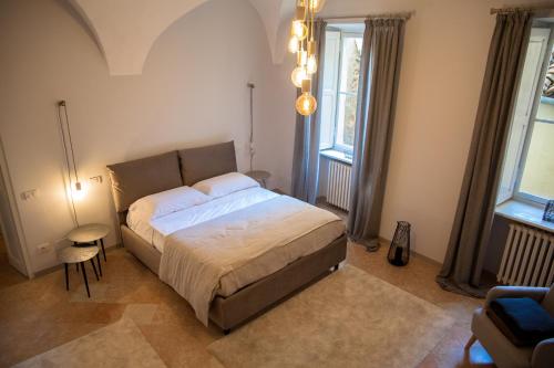 a bedroom with a large bed and two windows at R&B Il Viavai in Mondovì