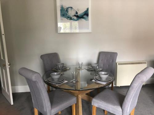 a dining room table with two chairs and a glass table at The Croft in Oakham
