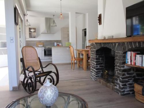 a living room with a stone fireplace and a table at Lou Pastourel in Le Lavandou