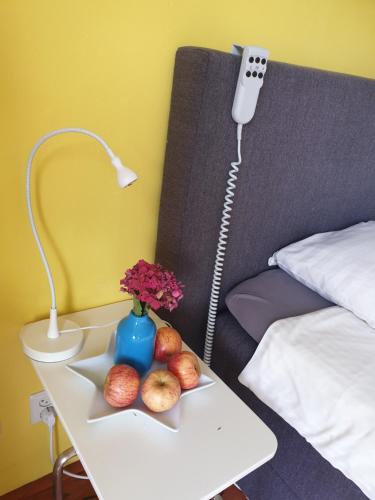 a bed with a table with fruit and a phone at Bed & Bye Schiphol in Badhoevedorp