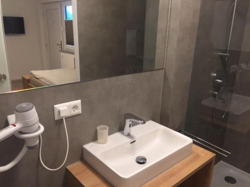 uma casa de banho com um lavatório branco e um espelho. em Apartments Thomas Britsch em Ilsfeld