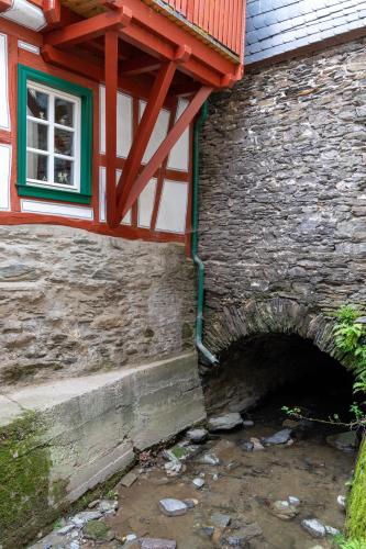 a stone building with a bridge and a window at Altkölnischer Hof in Bacharach