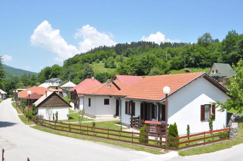 a row of houses with red roofs on a road at Apartmani LUX in Kolašin