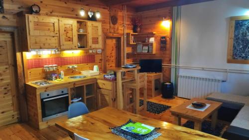 a kitchen with wooden cabinets and a table in a room at Apartments Life in Kolašin