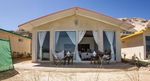 a house with a patio with chairs and a table at PK25 Dakhla in Dakhla