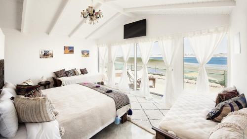 a bedroom with two beds and a view of the ocean at PK25 Dakhla in Dakhla