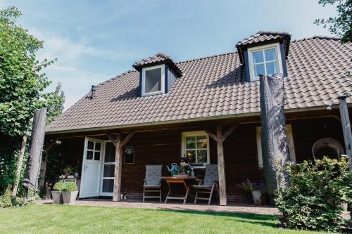a cottage with a table and chairs in the yard at Blauwe Lucht in Deurne