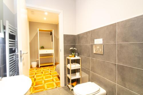 bagno con servizi igienici bianchi e pavimento giallo di Maison Amelie a Trieste