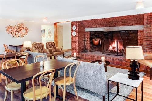 a living room with a fireplace and tables and chairs at The Ellery in Northampton