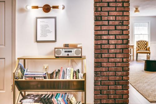 a book shelf with a radio on it next to a brick wall at The Ellery in Northampton