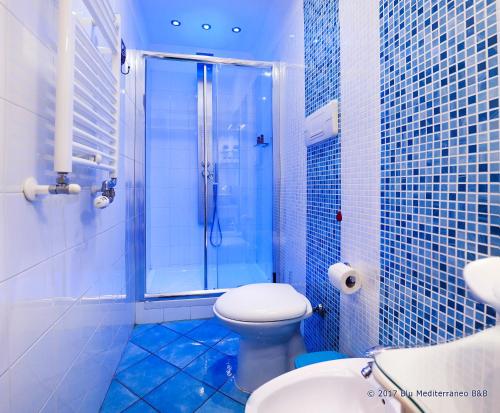 uma casa de banho em azulejos azuis com um WC e um chuveiro em Blu Mediterraneo B&B em Messina
