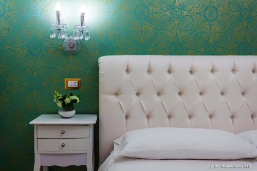 a bedroom with a white bed and a green wall at Blu Mediterraneo B&B in Messina