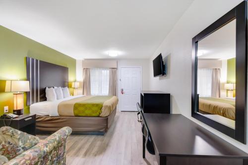 a hotel room with two beds and a mirror at Super 8 by Wyndham Palestine TX in Palestine
