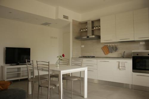 een witte keuken met een tafel en stoelen. bij casa in campagna alle porte di Rimini 3min fiera 3 min mare in Rimini