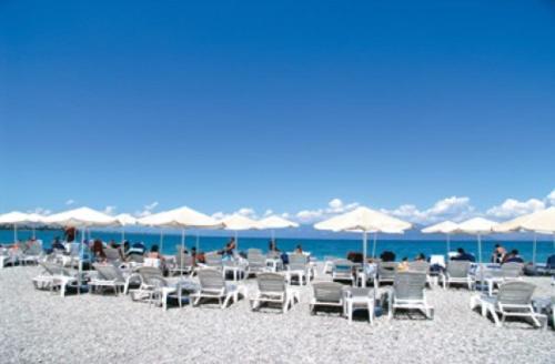 a group of chairs and umbrellas on a beach at Hotel Themisto in Nikolaíika