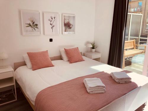 a bedroom with a large white bed with towels on it at New Port apartment in Nieuwpoort