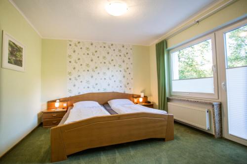 sypialnia z 2 łóżkami i oknem w obiekcie Pension Haus am Walde w mieście Schmallenberg